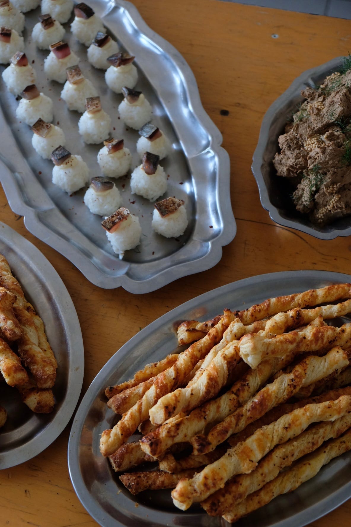 Onigiri au maquereau, gressins feuilletés et pâté de campagne sur plateaux argentés