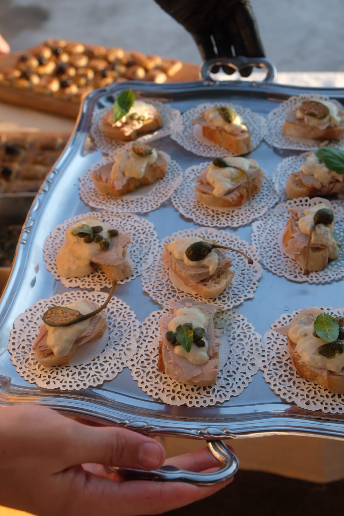Plateau de baguettes au levain, vitello tonnato et cucunci, présenté à la main